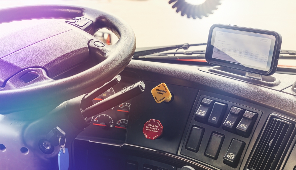 Interior of modern semi truck interior cabin with electronic log boog screen on dashboard. Trucking business with details of dashboard .